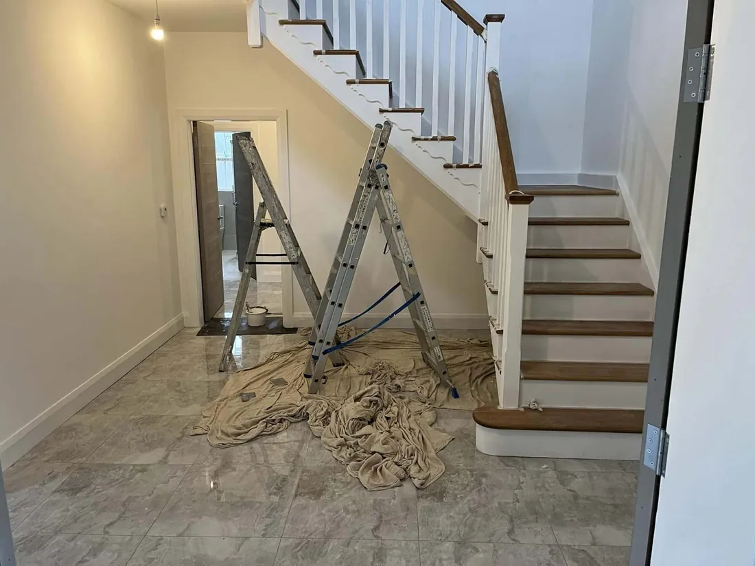 New timber staircase with white spindles in a renovated hallway